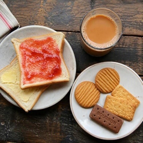 Tea with bread, butter, jam and biscuits