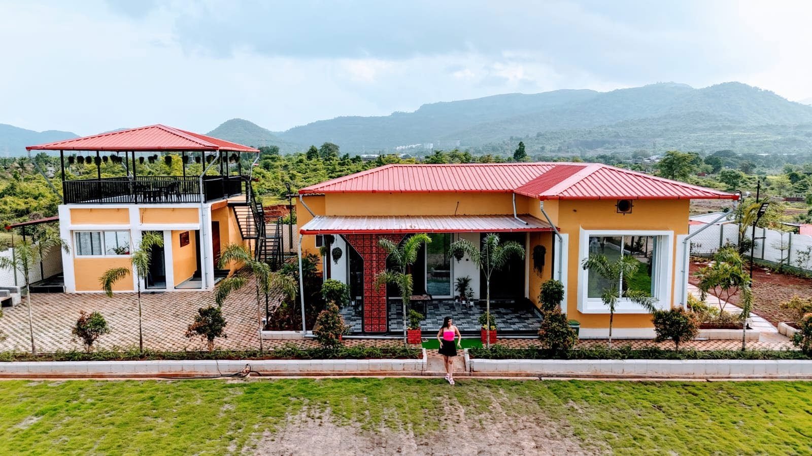 The farmhouse with open lawns and hills behind